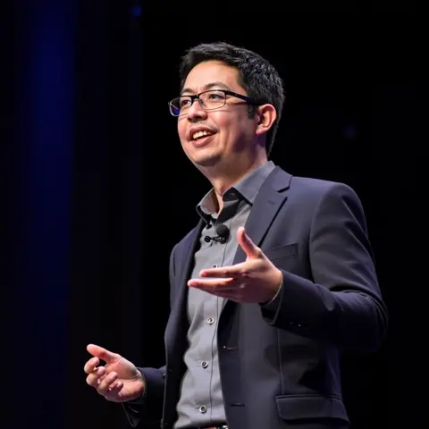 Melvin Vivas presenting in a suit